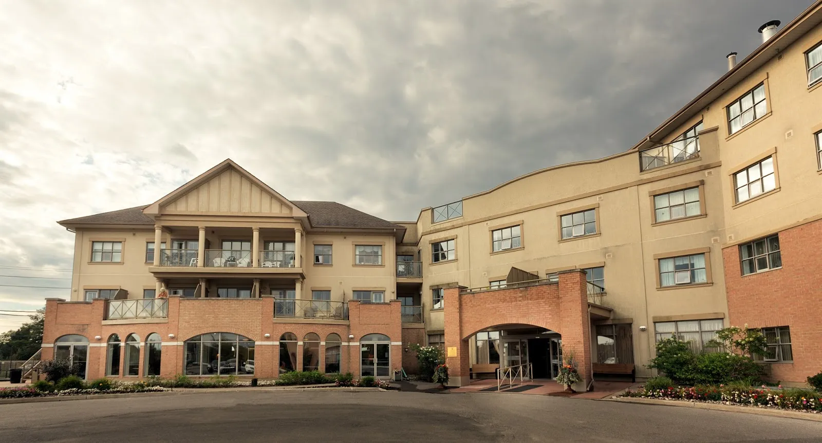 Exterior entrance and curved residential wings of Amica Swan Lake in Markham